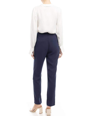 back side view of woman wearing white blouse and navy pants
