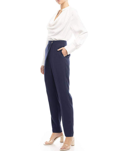 side view of a woman wearing a white blouse and navy pants