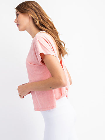 Woman wearing a coral workout shirt. 